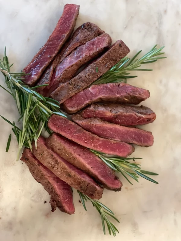 Sliced Beef With Rosemary on White Surface.